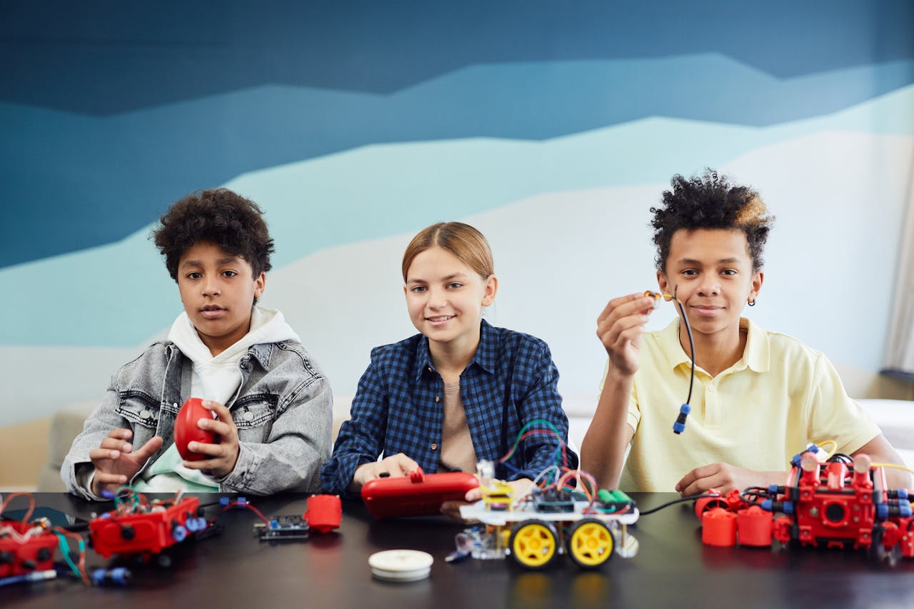 Three children working together on a robotics project indoors. Educational teamwork activity.